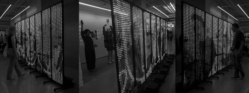 people looking at a large screen of LEDs in an indoor space